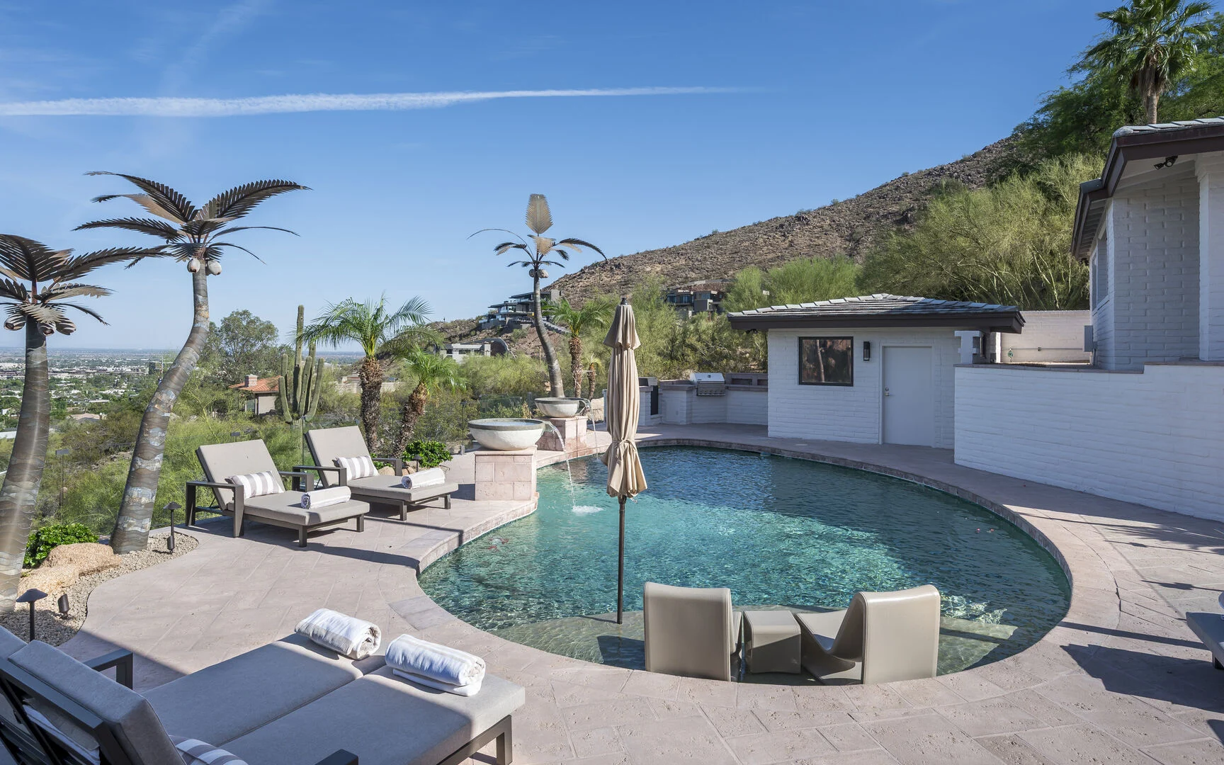 Resort-style pool with loungers in afternoon sun