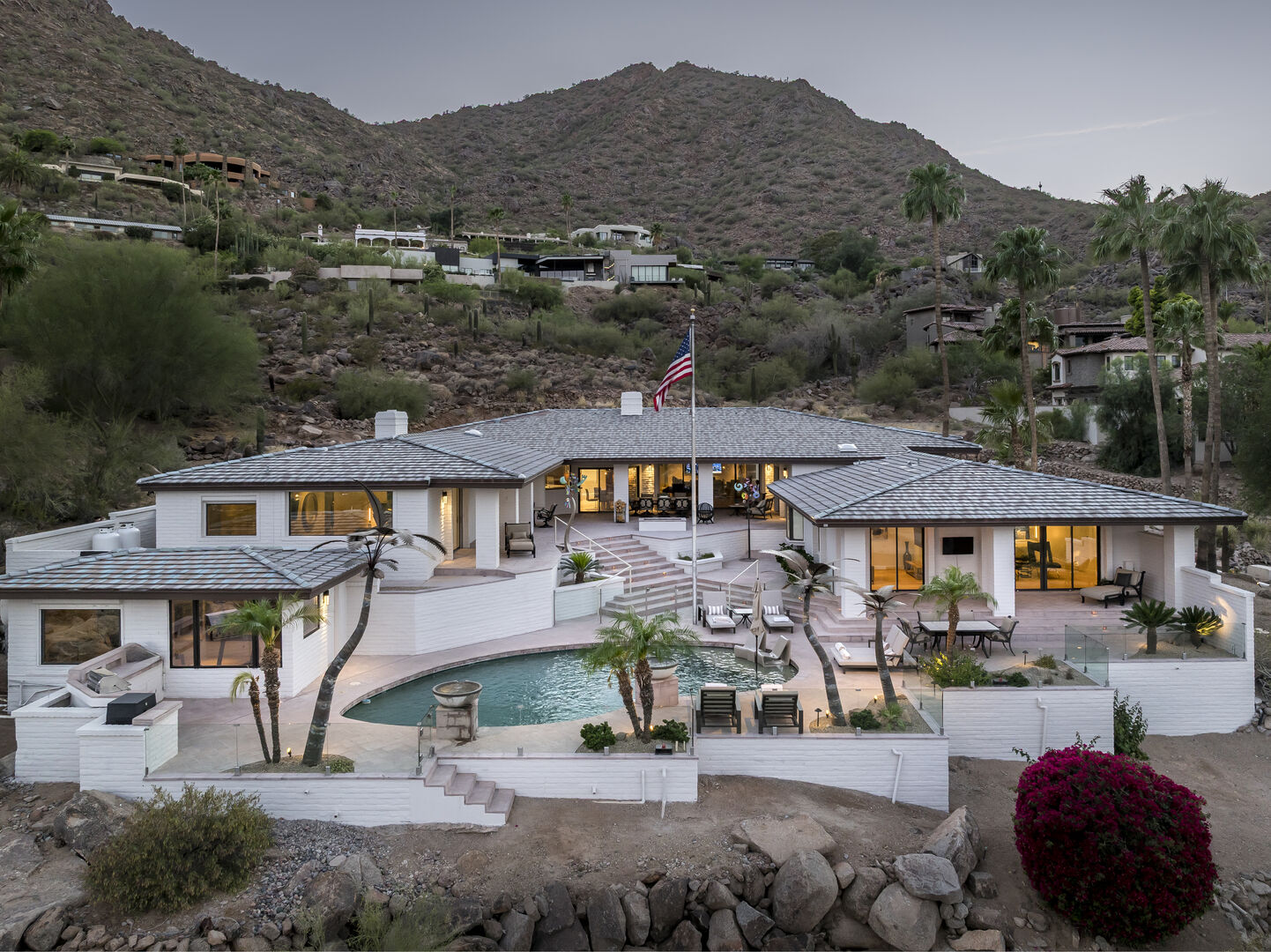 Contemporary desert estate on a hillside with palms and mountain backdrop